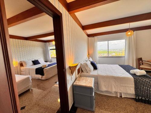 a bedroom with a bed and a couch and a window at Villa Nautilus Be Happy in Fortaleza
