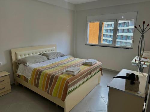 a bedroom with a bed and a desk and a window at Sea view Appartment in Shëngjin
