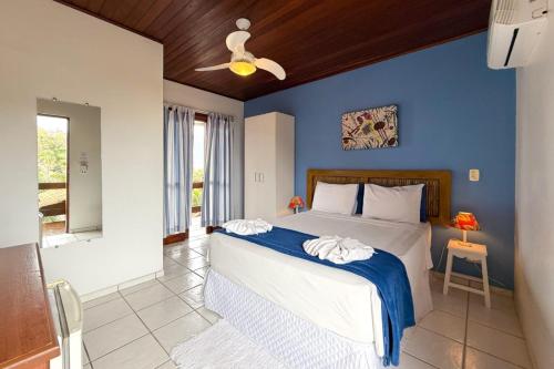 a bedroom with a large bed with a blue wall at Pousada Fruto do Mar in Ilhabela