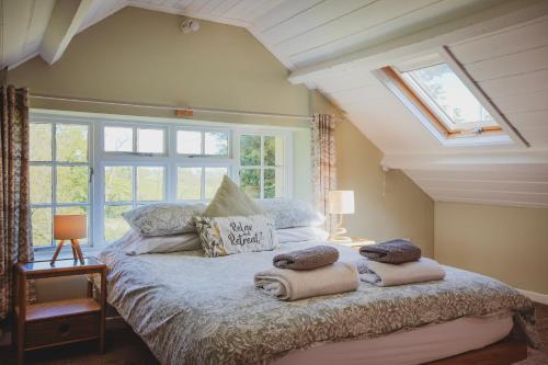 a bedroom with a bed with towels on it at Plasbach Cottage in Llandeilo