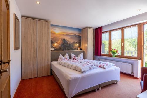 a bedroom with a bed and a painting on the wall at Gästehaus Wolfgang Taubensee in Ruhpolding