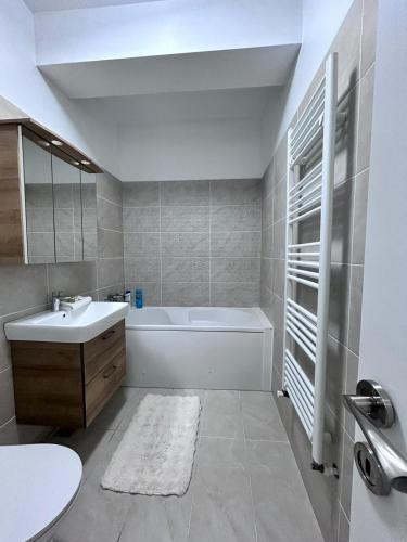 a bathroom with a white tub and a sink and a bath tub at Marina Evo Apartments in Mamaia Sat/Năvodari