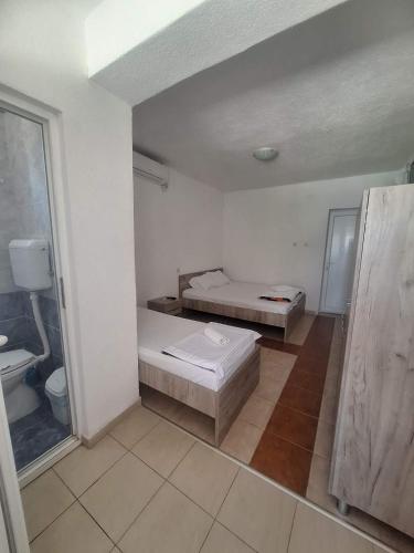 a white room with two beds and a window at Apartment Chukov in Star Dojran