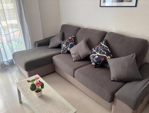 a gray couch with pillows in a living room at El Patio de Chus by Clabao in San Javier