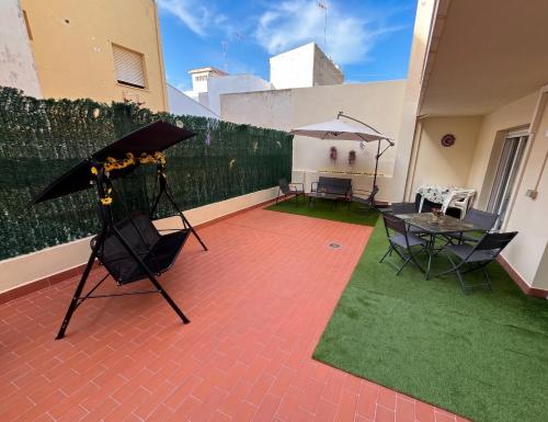a patio with an umbrella and a table and chairs at El Patio de Chus by Clabao in San Javier