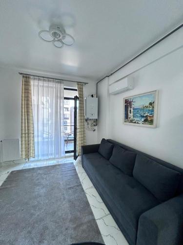 a living room with a couch and a window at Marina Evo Apartments in Mamaia Sat/Năvodari