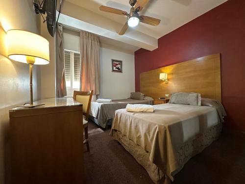 a hotel room with two beds and a lamp at Hotel coventry in Santiago del Estero