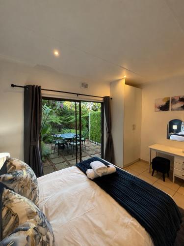 a bedroom with a bed and a desk and a table at Cottage in Ballito in Ballito