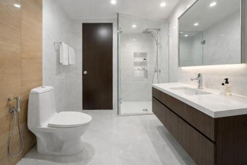 a bathroom with a toilet and a sink and a shower at Hotel Vista by Booksy One Kollam Near Kollam Bypass in Kollam