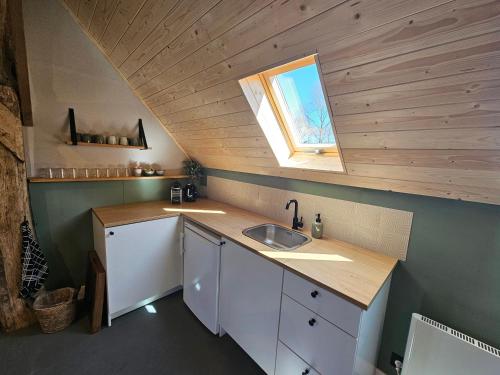 a small kitchen with a sink and a window at B&B De Emmer in Noord-Sleen