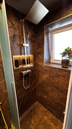 a bathroom with a shower and a window at Apartmán Artemis in Košice