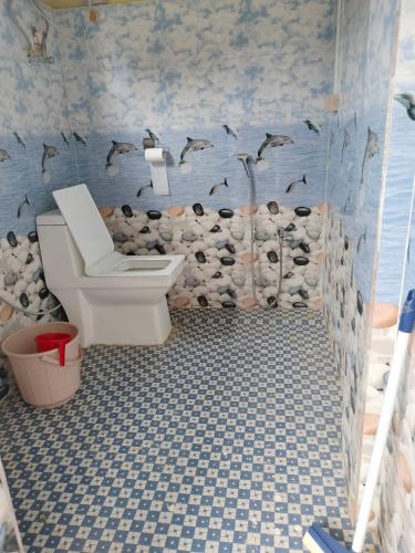 a bathroom with a toilet and birds on the wall at Nima homestay in Dirang Dzong