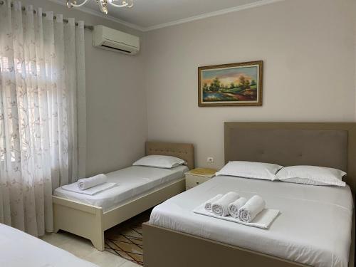 a bedroom with two beds and a window at Unejs Apartment in Berat