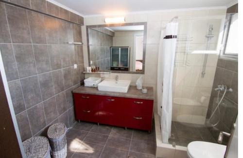 a bathroom with a sink and a shower and a mirror at Romanou Guest House in Romanón