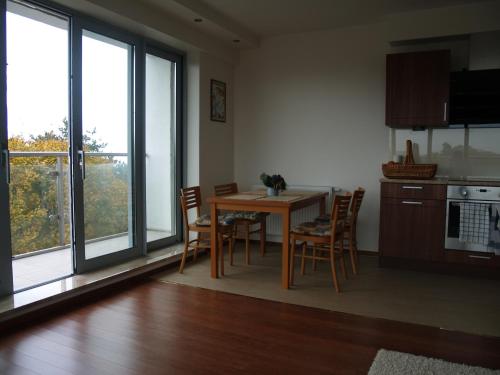 a kitchen with a table and chairs and windows at Wechta with Sea View and Sauna Gratis in Międzyzdroje