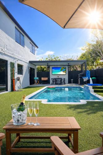a backyard with a pool and a table with wine glasses at Casa Madrisqui Heated Pool Oasis 12 Guests Midway Keys & Miami in Homestead