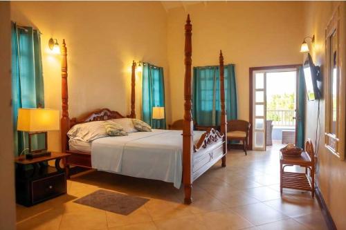 a bedroom with a bed with a four poster bed sidx sidx sidx sidx at Emerald Bleu Villa in Gros Islet