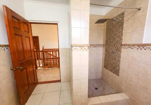 a bathroom with a shower with a glass door at Emerald Bleu Villa in Gros Islet