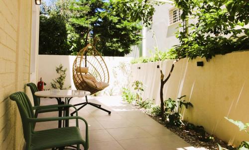 a patio with a table and chairs and a fence at FaliroRelax F2 in Athens