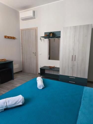 a bedroom with a blue bed with towels on it at B&B Casa Lina in Sarroch