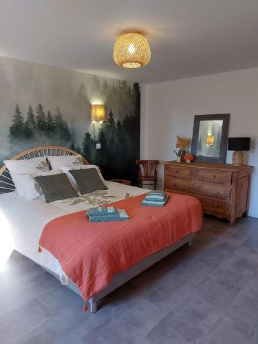 a bedroom with a large bed and a painting on the wall at La Maison d'André in Digny