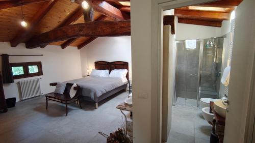 a bedroom with a bed and a bathroom with a shower at La Torre di Longara in Calderara di Reno