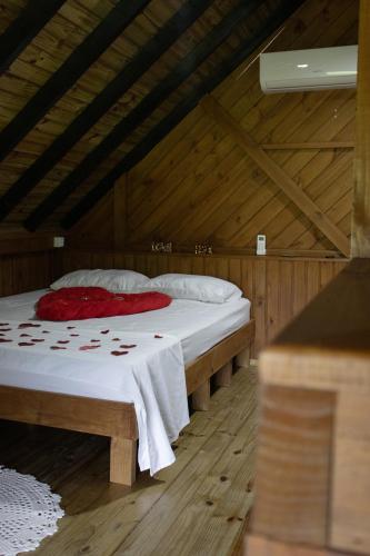 a bedroom with a bed in a wooden room at Recanto Deucher in Imaruí