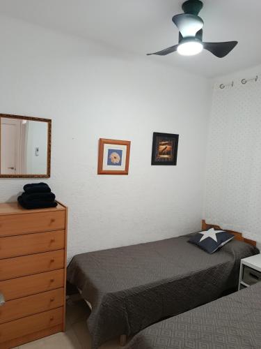 a bedroom with two beds and a dresser and a mirror at Ca la Nuri Pis 3 in Llança