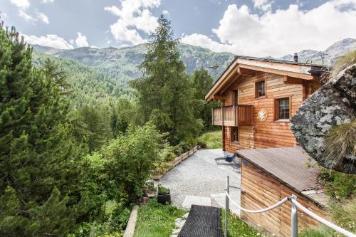 a log cabin in the mountains with a walkway at Chalet Hinter dem Rot Stei, private wellness, in ski and hiking area of Zermatt in Zermatt