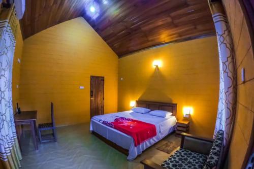 a bedroom with a bed and a table in a room at Walawa Wild Place in Udawalawe
