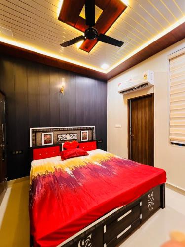 a bedroom with a red bed with a ceiling fan at Ophelia in Agra
