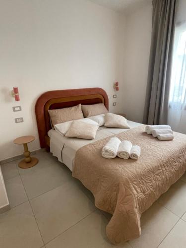 a bedroom with a bed with towels on it at Domus Luxi Teulada in Teulada