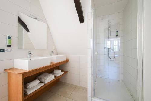 a bathroom with a sink and a shower at Hôtel Restaurant Le Commerce in Navarrenx