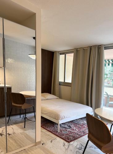a bedroom with a bed and a table and chairs at Cozy Studio, Pool & Beaches 2 min away in Roquebrune-Cap-Martin