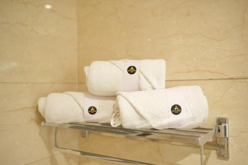 a pile of towels on a shelf in a bathroom at Alaukik Hotel in Shirdi
