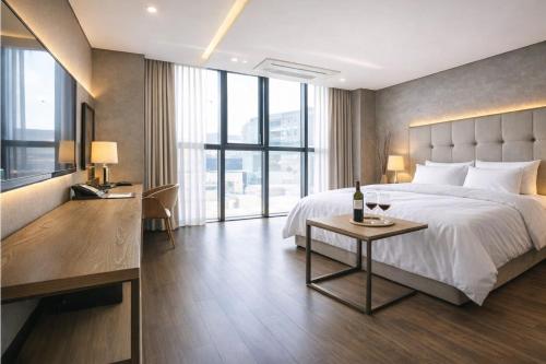 a bedroom with a bed and a table with a bottle of wine at Seoul Ahava Hotel in Seoul