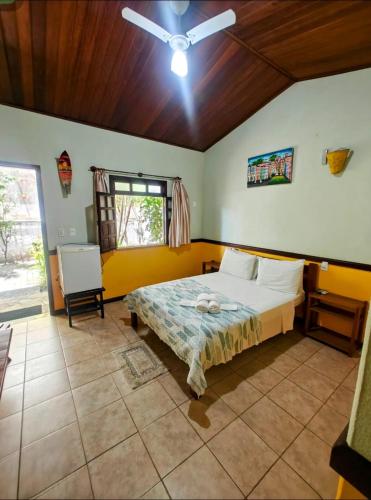 a bedroom with a bed and a ceiling fan at Pousada Tropicalia in Itaparica