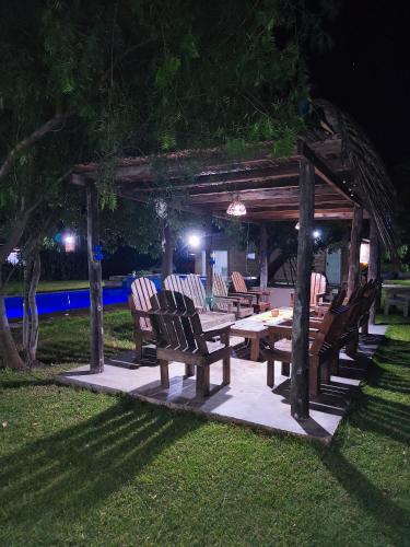 a picnic table and chairs under a gazebo at night at finca granja la soñadita in Santiago del Estero