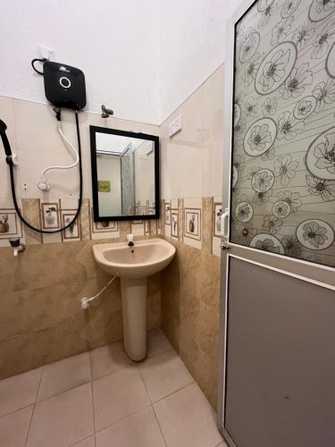 a bathroom with a sink and a shower and a mirror at Lumieri Hotel Arugambay in Arugam Bay