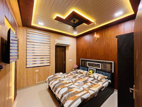 a bedroom with a large bed with a ceiling at Hogwood in Agra
