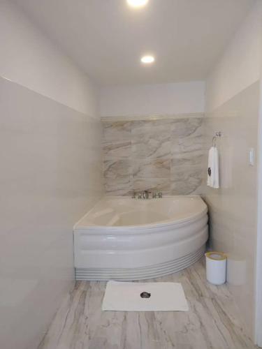 ein weißes Badezimmer mit Badewanne und weißem Teppich in der Unterkunft Carrizal in Barinas