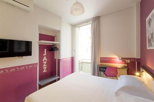 a bedroom with a bed and a desk and a tv at Sure Hotel by Best Western Nologo in Genoa