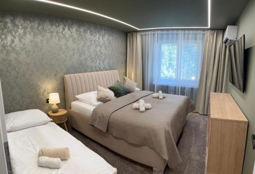 a bedroom with two beds and a window at Apartmán Artemis in Košice
