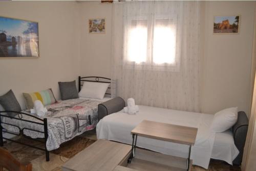 a living room with a bed and a couch at Stone-built house Vrontados Chios 3' from beach in Vrontádos