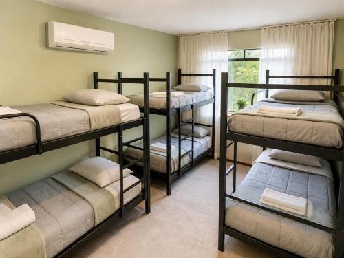 a room with four bunk beds and a window at Bergamota Hostel in Curitiba