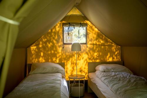 a room with two beds in a tent at Urban Gardens Ieper in Ieper