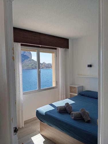 a bedroom with a bed and a large window at Oasis Mediterráneo in Ifach