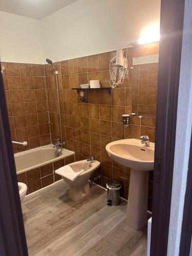 a bathroom with a sink and a toilet and a tub at HUMAN HOTEL RESTAURANT Park in Villecroze