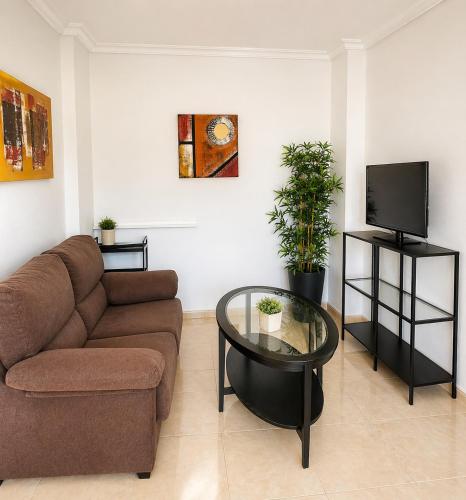 a living room with a couch and a glass table at La Riviera Residence in Rojales