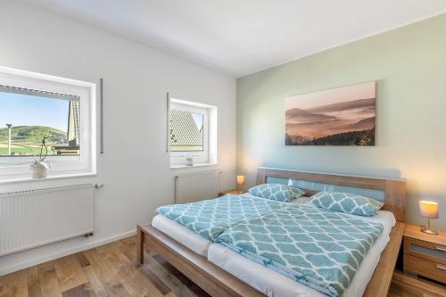 a bedroom with a bed and two windows at Ferienwohnung Dicke Linde, 55qm in Schmallenberg